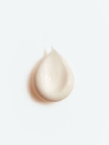 Texture de crème cosmétique travaillée à la spatule pour créer une image publicitaire élégante et raffinée destinée à l'univers du luxe.
